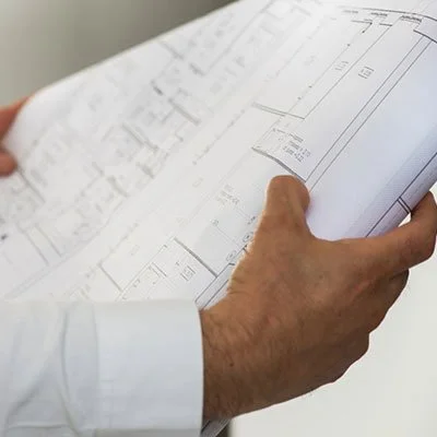 Person holding architectural blueprint or construction plans.